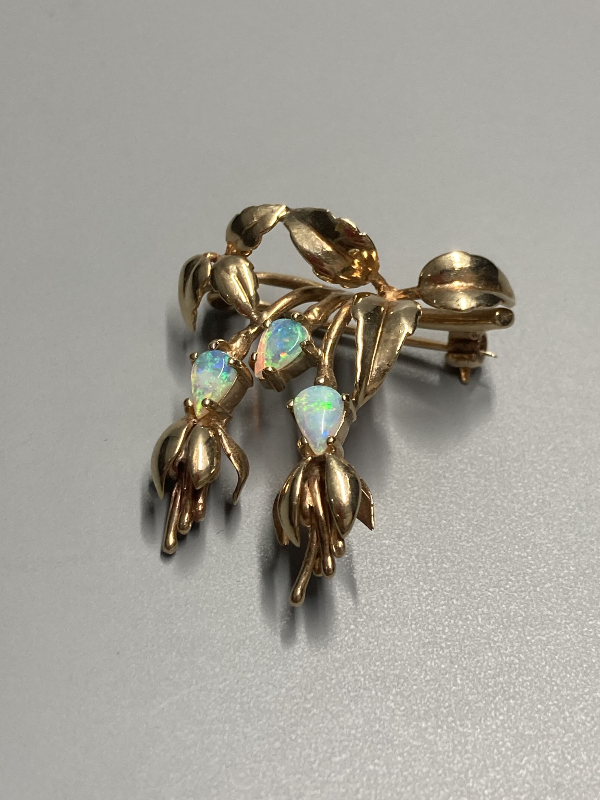 A modern 9ct gold and three stone white opal set foliate brooch, 32mm, gross 5.7 grams.